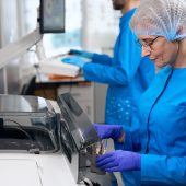 Laboratory staff use a special apparatus for automatic isolation of nucleic acids, people in blue uniforms